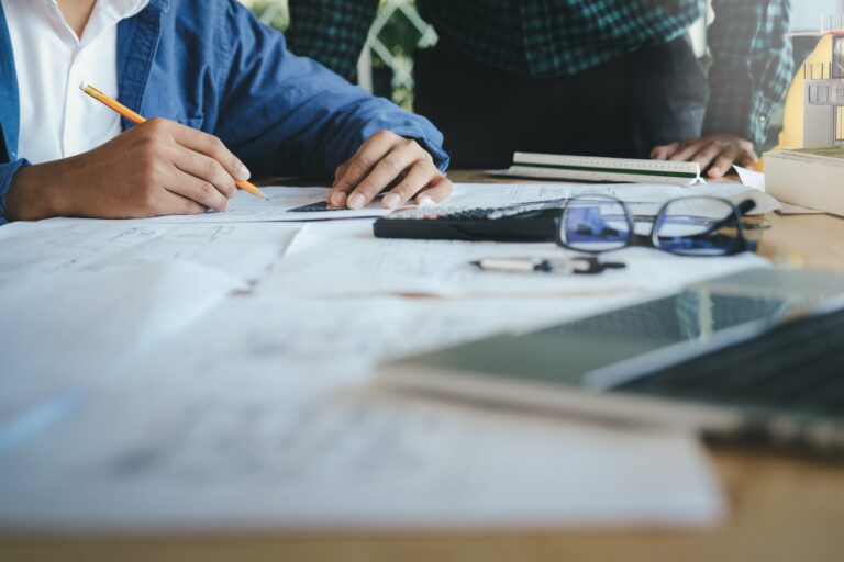 Architect or engineer team working with blueprints building plan design project in office